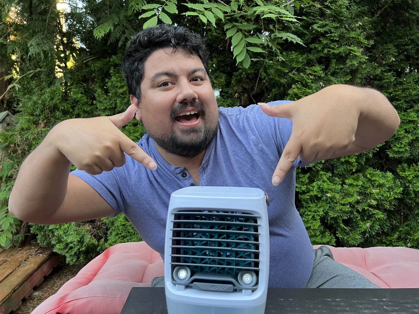 A tester sitting beside the Cwell 2.0 in a backyard